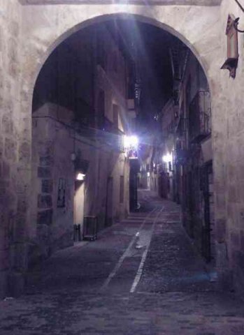 A winding street at night, in Pastrana, a charming medieval village in Guadalajara, Spain.